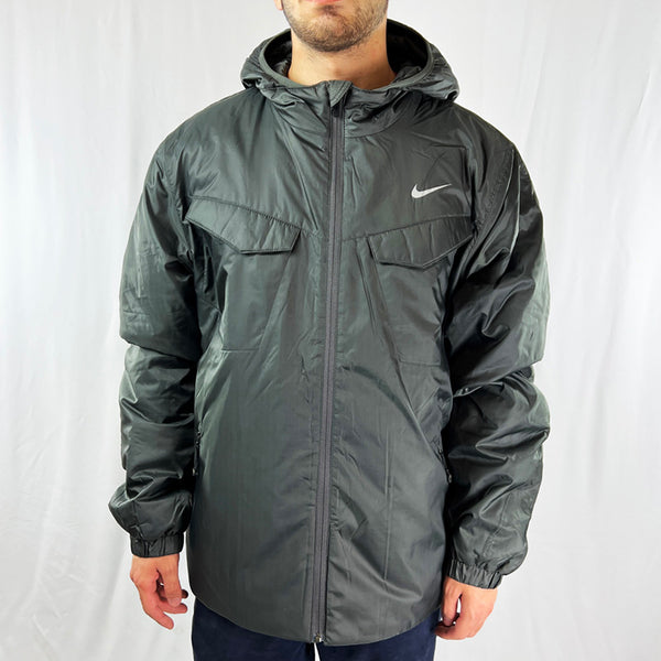 2009 Deadstock Vintage Nike Athletic Jacket in Dark Grey. Nike Swoosh to chest. Pockets to front. Zip closure. Hooded jacket. Adjustable cord to waist. Lightweight. Thermore light insulation technology. - Materials: Polyester - Colour: Dark Grey Brand New with Tags - Size on Tag: XL Measurements: Pit to Pit: 27 Inches Length: 29 Inches