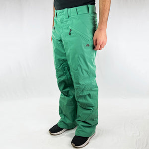Y2K Women's Deadstock Vintage Nike ACG Cargo Ski Pants in green with Nike ACG branding. Storm-Fit technology. Thermore light insulation fleeced inner layer. Zip pockets to sides and inner thigh. Boot gaiters. Belt loops for belt adjustment. - Materials: Body: Nylon Fill: Polyester