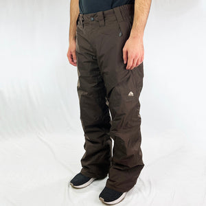 Y2K Women's Deadstock Vintage Nike ACG Cargo Ski Pants in brown with Nike ACG branding. Storm-Fit technology. Classic fit. Fleeced inner layer. Zip pockets to sides. Boot gaiters. Belt loops for belt adjustment. - Materials: Body: Nylon Fill: Polyester