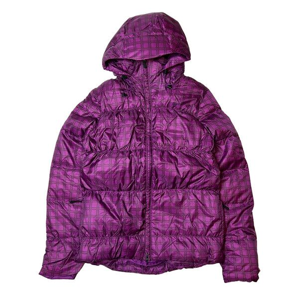 Y2K Women's Deadstock Vintage Nike puffer jacket in purple. Nike swoosh logo to chest. Full zip closure. Pockets to front. Inner pockets. Adjustable cord to waist. Elastic stretch from pit to pit. Adjustable cord to hood. Packable feature. 800 down fill power. - Material: Body: Polyester Fill: Down