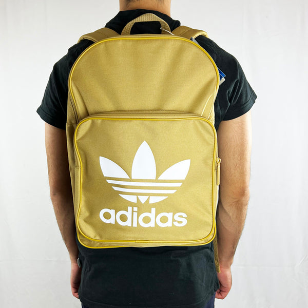 Adidas Originals Trefoil Backpack bag in beige. The perfect way to style up any outfit, this backpack has an all around zip large compartment. An all round zip smaller compartment with Adidas Originals logo on the front. Can fit a large size laptop. Colour: Beige Brand New with Tag One Size