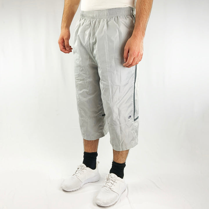 90s Deadstock Vintage Nike Swoosh Long Shorts in Grey. Nike swoosh to front and back. Adjustable drawstring to waist. Pockets to sides. Nylon material.