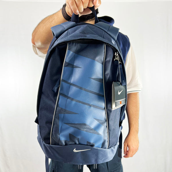 2004 Deadstock Vintage Nike Spellout backpack in blue with embroidered Nike swoosh and large spellout. With its large laptop sleeve and roomy main compartment, this backpack is make to take you places. This backpack also has a front compartment. Unisex. Materials: Polyester  Colour: Blue Brand New with Tags  All our items are of vintage conditions. This means some items may show signs of minor wear. Any major defects will be pictured and stated in the description