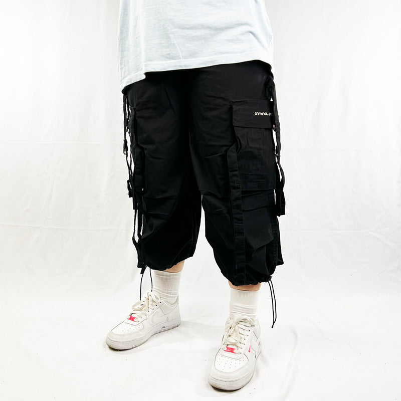 Y2K Women's Deadstock Vintage Criminal Damage Drome cargo shorts in black with Criminal Damage branding. Lattice style parachute cargos. Adjustable drawstring to waist. Pockets to side. Adjustable cord to hem.