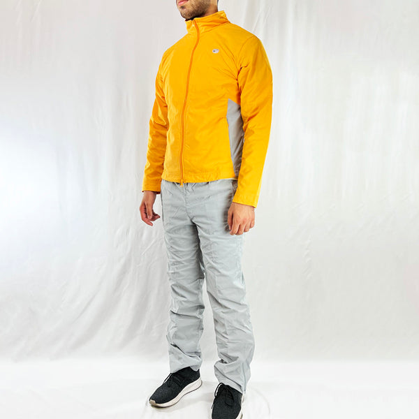 2002 Y2K Women's Deadstock Vintage Nike Swoosh tracksuit set in grey and yellow. Full zip closure and pockets available on track top and track bottoms. The matching pants in grey has an adjustable drawstring for a customised wear, Nike branding detailed on track top and track bottoms.