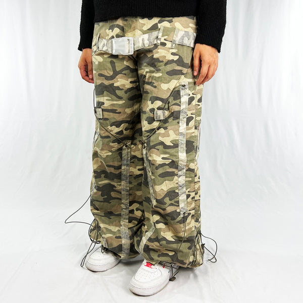 Super cute Deadstock Vintage Criminal Damage parachute cargo trousers in khaki camo with Criminal Damage embroidered logo. Pockets to front and back. Adjustable cord to hem. Belt for style. Medium/Low waist cargo pants