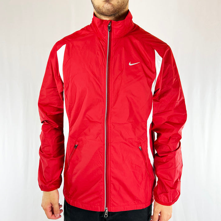 Y2k Deadstock Vintage Nike Just Do It windbreaker jacket in red. Nike swoosh to chest. Full zip closure. Zip pockets on side. Adjustable cord to hem. Reflective feature. Materials: Nylon Colour: Red Brand New with Tags