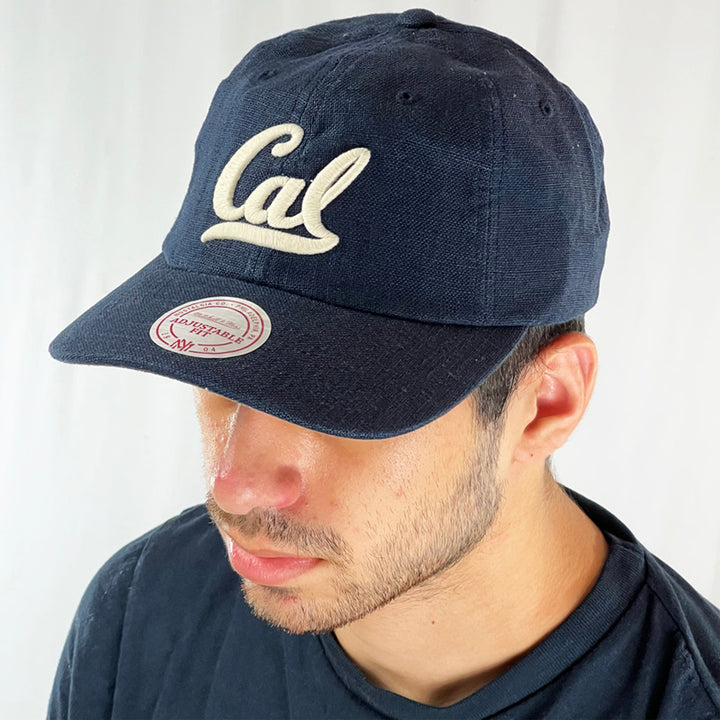 Support the California Golden Bears athletic team with this low profile snapback cap. Finished in navy blue and paired with a curved visor, the fitted crow features the iconic 'Cal' logo fully fitted for your complete comfort in a range of sizes. Mitchell & Ness embroidery to rear Colour: Navy Blue Brand New with Tags - Size on Tag: One Size