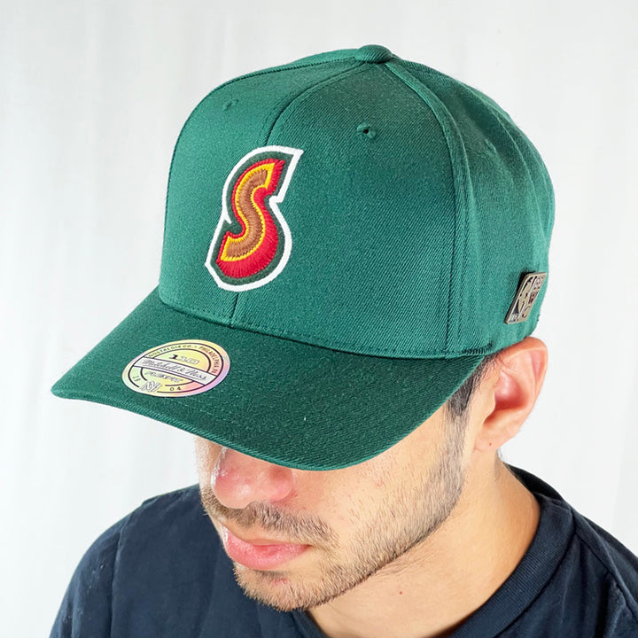 Support the NBA Seattle Supersonics basketball team with this low profile snapback cap. Finished in green and paired with a flat visor, the fitted crow features the Seattle Supersonics logo fully fitted for your complete comfort in a range of sizes. Mitchell & Ness embroidery to rear Colour: Green Brand New with Tags - Size on Tag: One Size