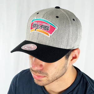 Support the NBA San Antonio Spurs basketball team with this low profile snapback cap. Finished in grey and paired with a black curved visor, the fitted crow features the iconic San Antonio Spurs logo fully fitted for your complete comfort in a range of sizes. Mitchell & Ness embroidery to rear Colour: Grey Brand New with Tags - Size on Tag: One Size