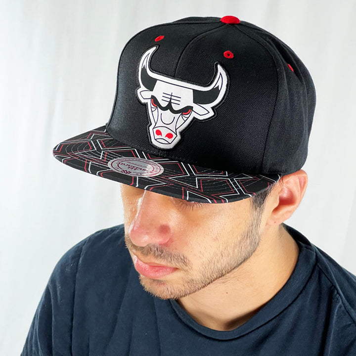 Support the NBA Chicago Bulls basketball team with this low profile snapback cap. Crafted with a high structured crown finished in black and paired with a flat visor, the fitted crow features the iconic Chicago Bulls logo fully fitted for your complete comfort in a range of sizes. Mitchell & Ness embroidery to rear Colour: Black Brand New with Tags - Size on Tag: One Size