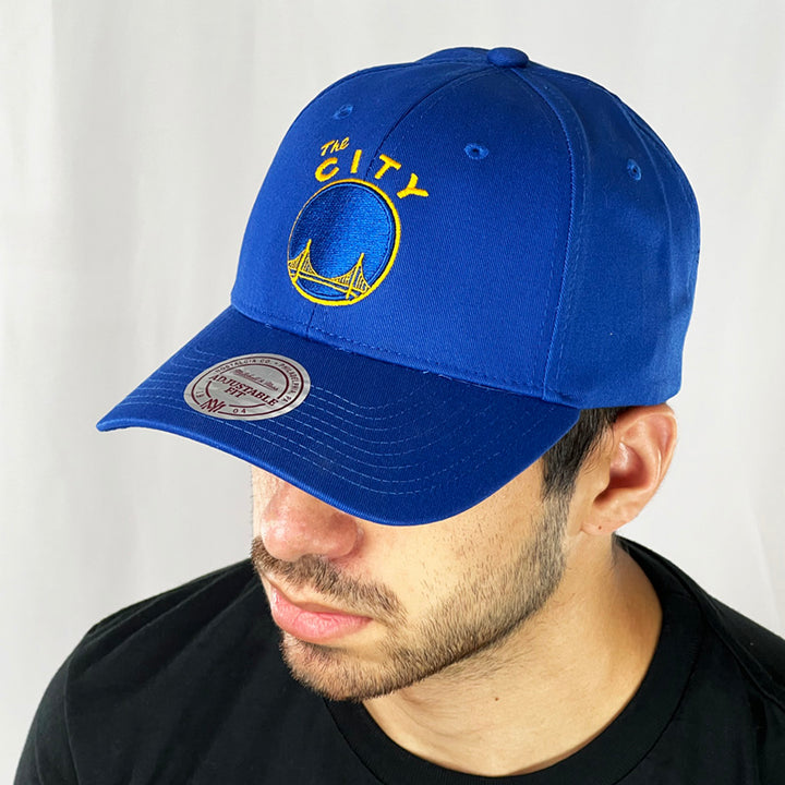 Support the NBA Golden State Warriors basketball team with this low profile snapback cap. Finished in blue and paired with a curved visor, the fitted crow features the iconic Golden State Warriors logo fully fitted for your complete comfort in a range of sizes. Mitchell & Ness embroidery to rear Colour: Blue Brand New with Tags - Size on Tag: One Size