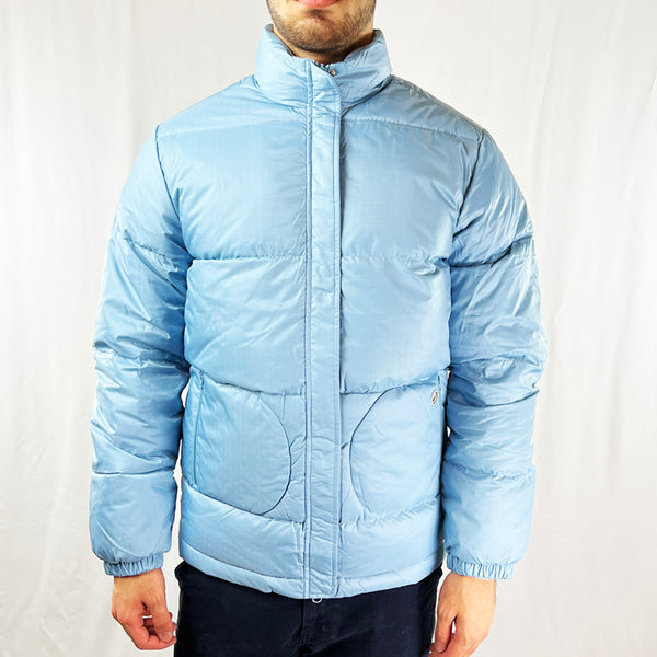 2002 Women's Deadstock Vintage Nike Swoosh Puffer Jacket in Baby Blue. Nike logo to pocket. Zip and button closure. Zip pockets to front and inner layer. Adjustable cord to waist. - Material: Polyester Fill: White Duck Down - Colour: Baby Blue Brand New with Tags - Size on Tag: Small Measurements: Pit to Pit: 21 Inches Length: 27 Inches