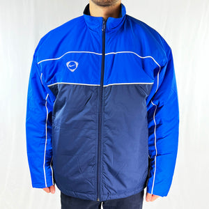 Y2K Deadstock Vintage Nike Team Jacket in Navy Blue. Embroidered Nike Football logo to chest and swoosh behind neck. Pockets to front. Zip closure. Adjustable cord to waist. Fleeced inner layer. - Materials: Nylon Fill: Polyester - Colour: Navy Blue Brand New with Tags - Size on Tag: Medium Measurements: Pit to Pit: 26 Inches Length: 29.5 Inches