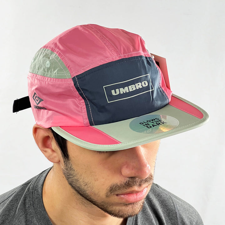 Deadstock Umbro morph cap in pink with glow in the dark feature. Flat visor. Umbro spellout to front and side. Adjustable strapback. Colour: Pink Brand New with Tags - Size on Tag: One Size
