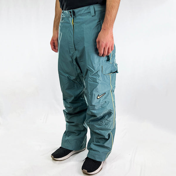 90s Women's Deadstock Vintage Nike ACG Cargo Snowboarding Pants in blue with Nike ACG branding. Plenty of pockets. Belt loops for belt adjustment. - Materials:  Shell: Nylon Lining: Polyester - Colour: Blue Brand New with Tags