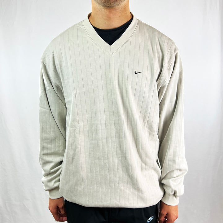 Y2K Deadstock Vintage Nike Golf reversible sweater in beige and black. Embroidered Nike swoosh to chest on beige side. Reversible side is black with the Nike Golf logo behind the neck, polyester material to keep you dry in rain, pockets to front. V neck. - Materials: Cotton/Polyester - Colour: Beige & Black
