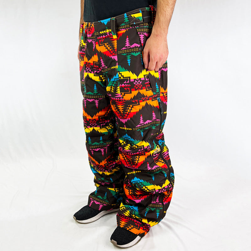 Y2K Women's Deadstock Vintage Nike ACG Gore-Tex Ski Pants in brown with multicoloured design. Nike ACG branding. Storm-Fit technology. Gore-Tex technology which is a waterproof, breathable fabric. Fleeced inner layer. Zip pockets. Boot gaiters. Belt loops for belt adjustment. Baggy fit. - Materials: Polyester - Colour: Brown