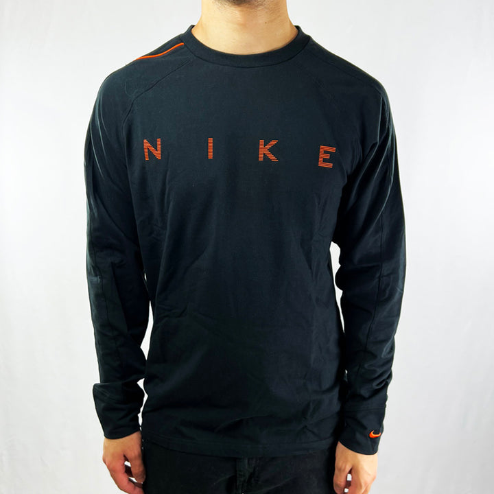Y2K Deadstock Vintage Nike spellout long sleeve top in black with spellout across chest in orange. Embroidered Nike swoosh to sleeve. Crew neck. - Materials: 95% Cotton 5% Elastane - Colour: Black Brand New with Tags