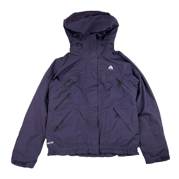 2008 Women's Deadstock Vintage Nike ACG Gore-Tex Jacket in Purple. Nike ACG logo to chest. Zip closure to jacket. Zip pockets to front. Adjustable cords to hood. Adjustable cord to waist. Thermore technology light insulation fleeced inner layer. Storm Fit technology suitable for the most extreme conditions. Gore-Tex technology a waterproof, breathable fabric. Inner pockets.