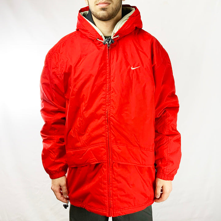Y2K Deadstock Vintage Nike Jacket in Red with fleeced inner layer. Hooded with adjustable cord. Zip pockets both outer and inner. Adjustable cord to hem.   Materials: Body: 100% Nylon Lining: 100% Polyester Trim: 100% Cotton - Colour: Red Brand New with Tags _ Size on Tag: Large Measurements: Pit to Pit: 26 Inches Length: 31 Inches