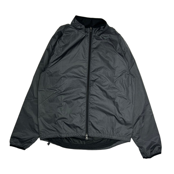 Y2K Deadstock Vintage Nike windbreaker jacket in black. Embroidered Nike swoosh to chest. Pockets to front. Zip closure to jacket. Lightweight. Clima-Fit technology. Reflective feature. adjustable cord to waist. - Materials: Nylon - Colour: Black Brand New with Tags - Size on Tag: Medium Measurements: Pit to Pit: 21.5 Inches Length: 25.5 Inches