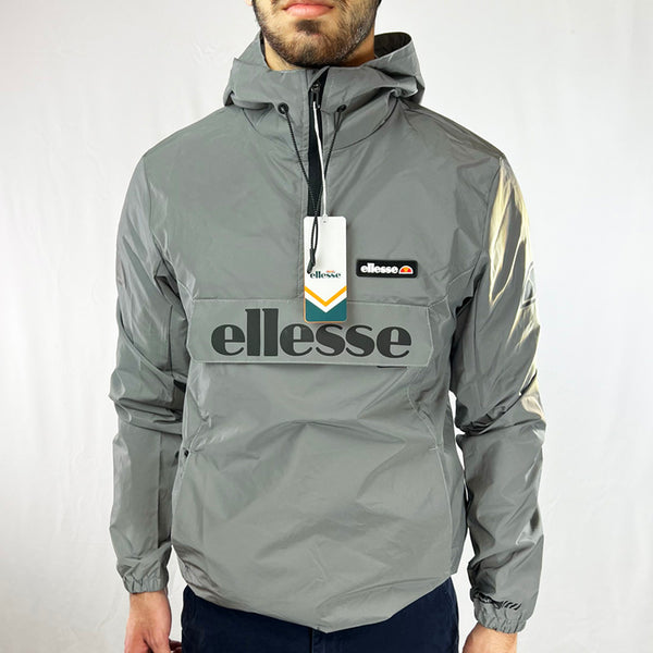 Deadstock Ellesse Berto 2 windbreaker jacket in silver. Ellesse logo across front. Pockets to front. 1/2 zip pullover jacket. Lightweight. Reflective feature. Elastic waist. - Materials: 100% Polyester - Colour: Silver Brand New with Tags - Size on Tag: Small Measurements: Pit to Pit: 21 Inches Length: 27.5 Inches