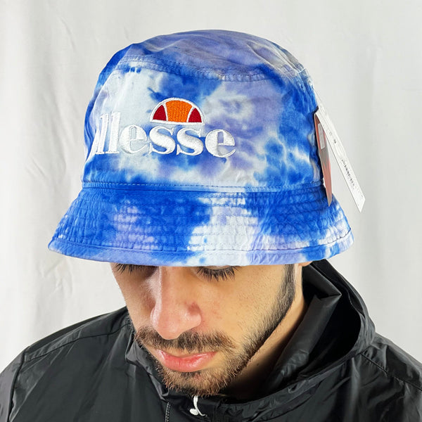 Deadstock Ellesse Hallan bucket hat in blue tie dye. Ellesse spellout to hat. Materials: 100% Cotton Colour: Blue Tie Dye Brand New with Tags - Size on Tag: One Size