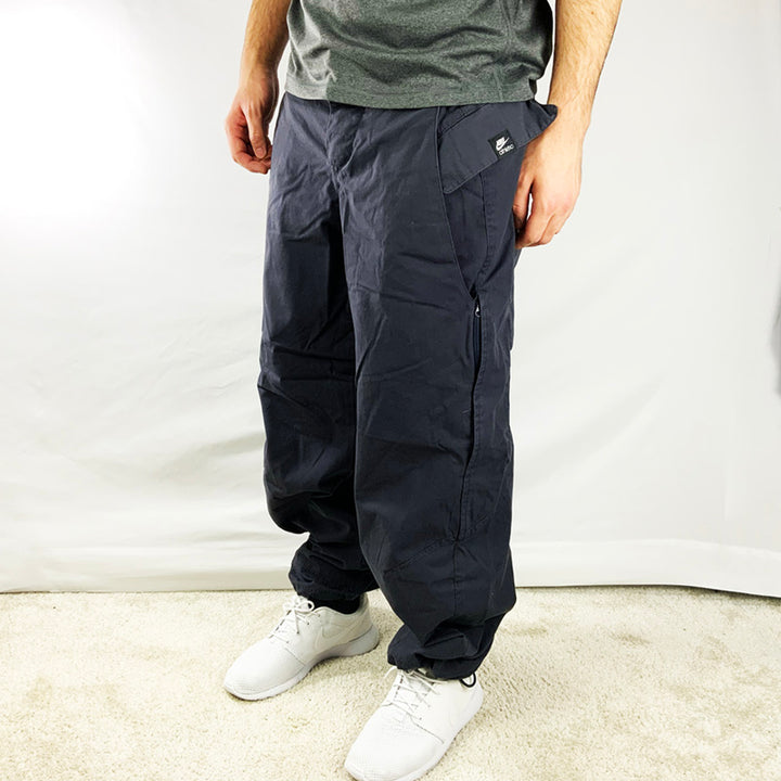  2007 Deadstock Vintage Nike Cargo Trousers in Grey with Nike Atheltic logo on pocket, Plenty of pockets, zip pockets on side, cord to tighten hem, adjustable waist.