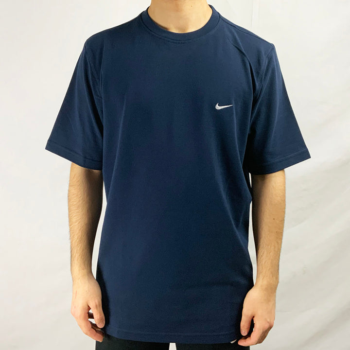 2002 Deadstock Vintage Nike Swoosh T-shirt in Navy with embroidered Nike swoosh to chest. Colour: Navy Blue  Brand New with Tags  _  Size on Tag: Large  Measurements:  Pit to Pit: 23 Inches  Length: 30 Inches  All our items are of vintage conditions. This means some items may show signs of minor wear. Any major defects will be pictured and stated in the description