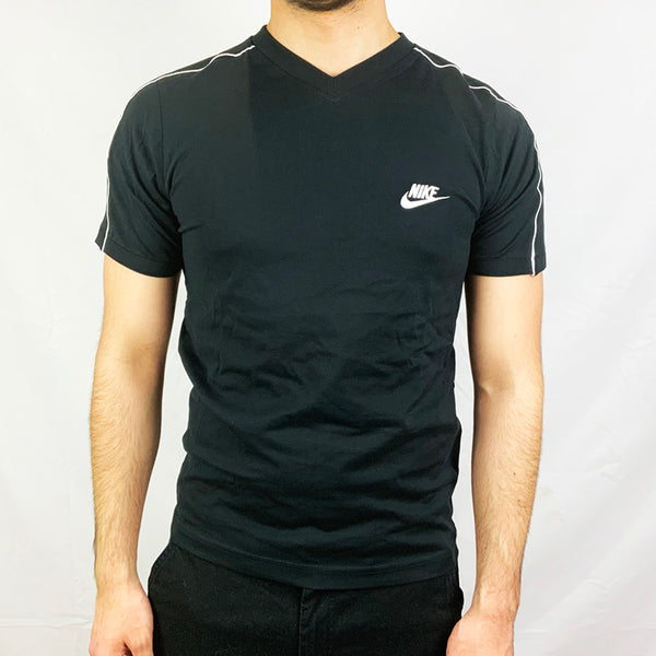 2006 Deadstock Vintage Nike Spellout T-shirt in black with Nike spellout to chest with swoosh. V-neck t-shirt. Colour: Black Brand New with Tags _ Size on Tag: Small Measurements: Pit to Pit: 18.5 Inches Length: 25.5 Inches  All our items are of vintage conditions. This means some items may show signs of minor wear. Any major defects will be pictured and stated in the description