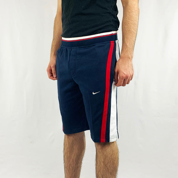 2004 Deadstock Vintage Nike shorts in navy blue with Nike swoosh to front. Adjustable drawstring to waist. Pockets to side. Colour: Navy Blue  Brand New with Tags  -  Size on Tag: Small  Measurements:  Length: 20.5 Inches  Waist: GB 28/30  All our items are of vintage conditions. This means some items may show signs of minor wear. Any major defects will be pictured and stated in the description