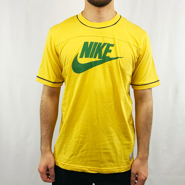 2006 Deadstock Vintage Nike Spellout T-shirt in yellow with green Nike spellout across chest giving it that tropical brazil feel. Colour: Yellow Brand New with Tags _ Size on Tag: Large Measurements: Pit to Pit: 21 Inches Length: 27.5 Inches  All our items are of vintage conditions. This means some items may show signs of minor wear. Any major defects will be pictured and stated in the description
