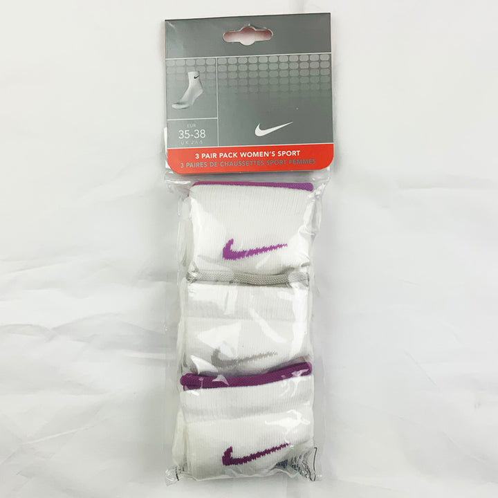 3 Per Pack Y2k Women's Deadstock Vintage Nike Sports Socks in White. Socks has 3 different coloured Nike Swoosh. Purple swoosh, grey swoosh and dark purple swoosh Colour: White  Brand New with Tags -  SIZE ON TAG: 2.5 - 5  All our items are of vintage conditions. This means some items may show signs of minor wear. Any major defects will be pictured and stated in the description