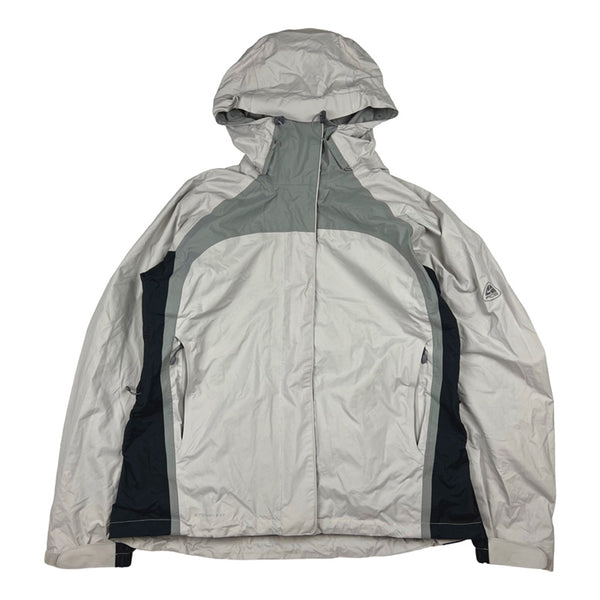 2003 Women's Deadstock Vintage Nike ACG jacket in grey. Nike ACG logo to sleeve. Two way zip closure. Zip pocket to chest. Zip pockets to front at sides. Adjustable cord to hood. Inner media compartment. Storm Fit technology. Adjustable wrist. Adjustable cord to waist. Zipped in ski skirt to inner layer.