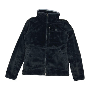 2008 Women's Deadstock Vintage Nike ACG 20th anniversary winstopper soft shell fleece jacket in black. Nike ACG logo to chest. Two way zip closure to jacket. Zip pocket to chest. zip pockets to front. Adjustable cord behind neck. Adjustable cord to waist. High neck. Gore wind stopper. - Material: 100% Polyester - Colour: Black Brand New with Tags