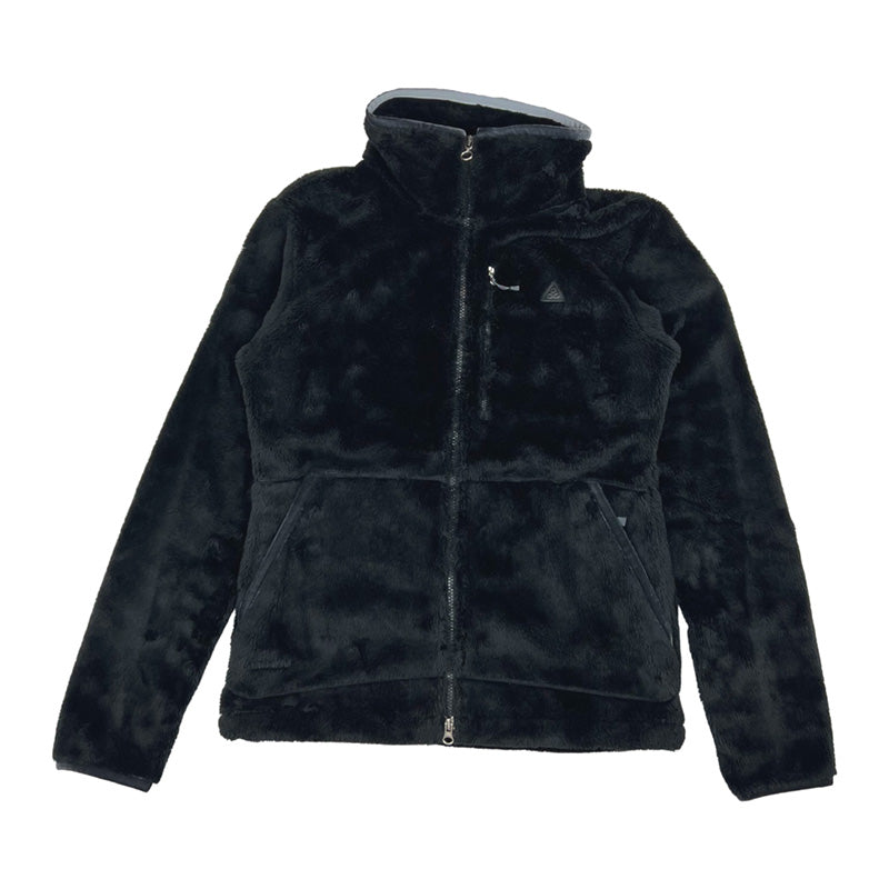 2008 Women's Deadstock Vintage Nike ACG 20th anniversary winstopper soft shell fleece jacket in black. Nike ACG logo to chest. Two way zip closure to jacket. Zip pocket to chest. zip pockets to front. Adjustable cord behind neck. Adjustable cord to waist. High neck. Gore wind stopper. - Material: 100% Polyester - Colour: Black Brand New with Tags