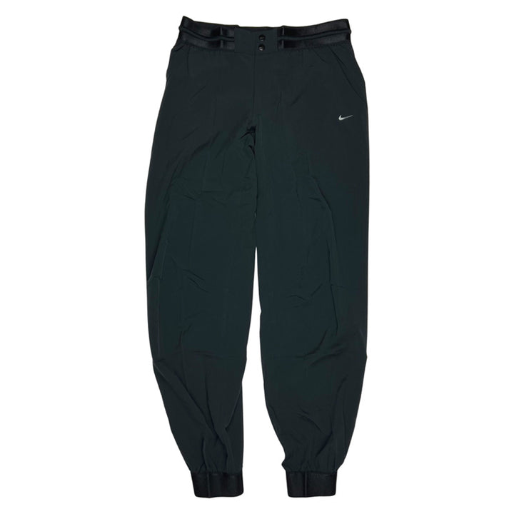 2012 Women's Deadstock Vintage Nike Joggers in black. Reflective Nike swoosh logo. Pockets to front. Pocket to back. Elastic waist with drawstrings for adjustability. ankle cuffs for fitted look.